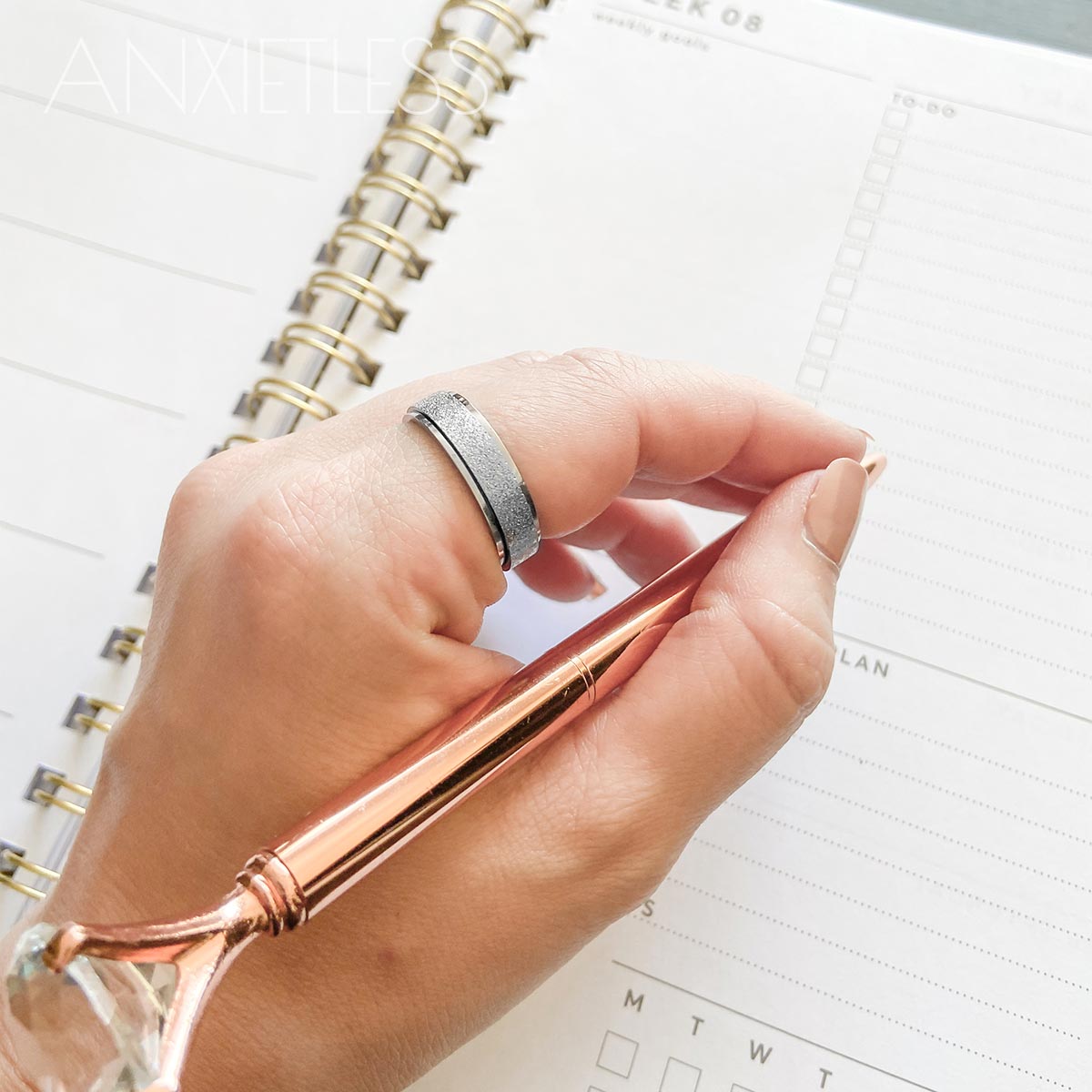 Woman Wearing Silver Anxiety Ring, Holding Rose Gold Pen, Writing in Diary