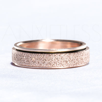 Sparkly Rose Gold Anxiety Ring Laid Flat on White Background